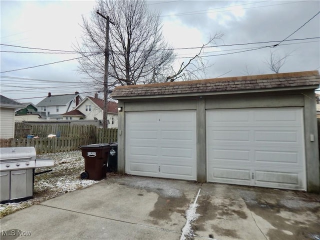 detached garage featuring fence