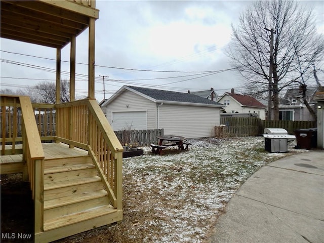 exterior space with an outbuilding, a deck, a detached garage, fence, and stairway