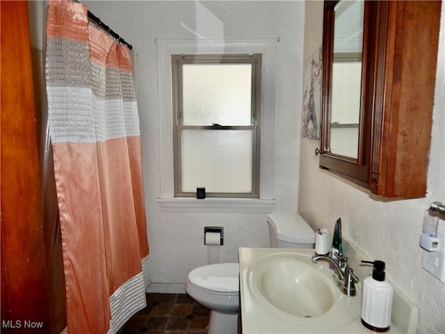 bathroom featuring a shower with shower curtain, a sink, toilet, and tile patterned floors