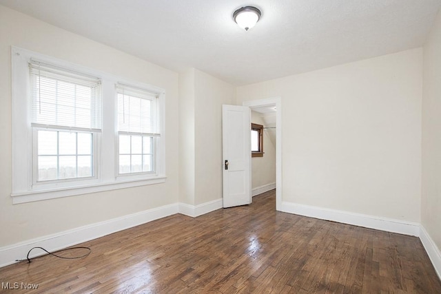 unfurnished room featuring wood finished floors and baseboards