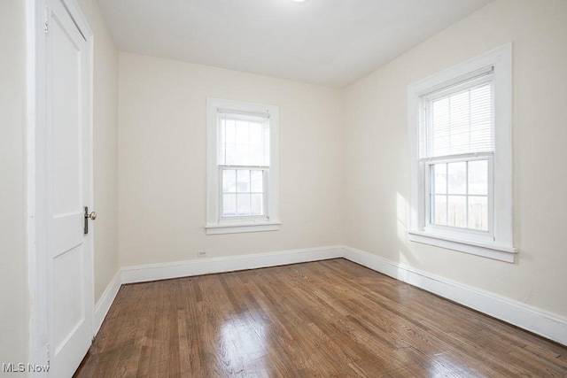 empty room with baseboards and wood finished floors