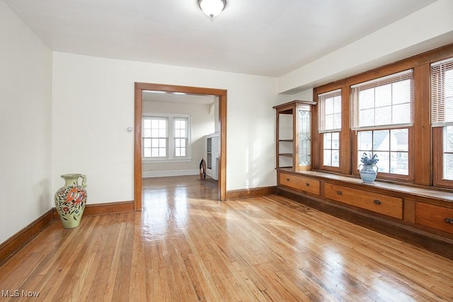 unfurnished room with light wood-style flooring and baseboards