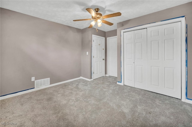 unfurnished bedroom with carpet, a closet, visible vents, and a textured ceiling