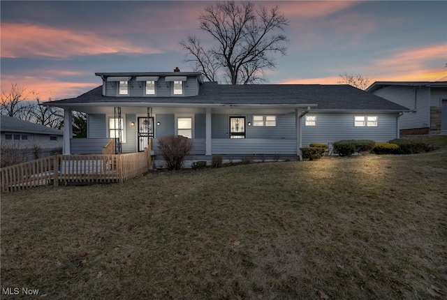 view of front of property featuring covered porch, a lawn, and fence