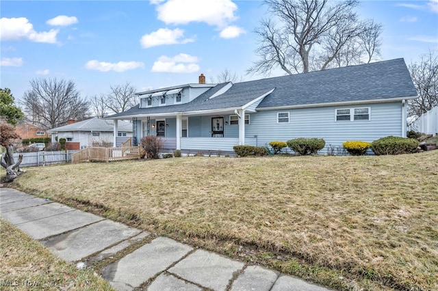 view of front of property with a chimney, a shingled roof, covered porch, a front yard, and fence