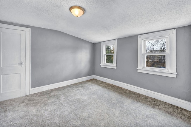 carpeted spare room with baseboards and a textured ceiling