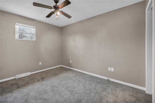 carpeted spare room with a ceiling fan, visible vents, and baseboards