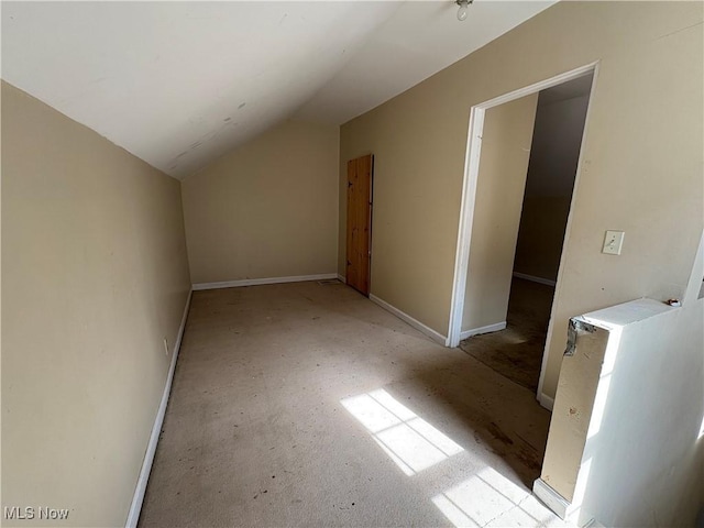 additional living space with lofted ceiling and baseboards