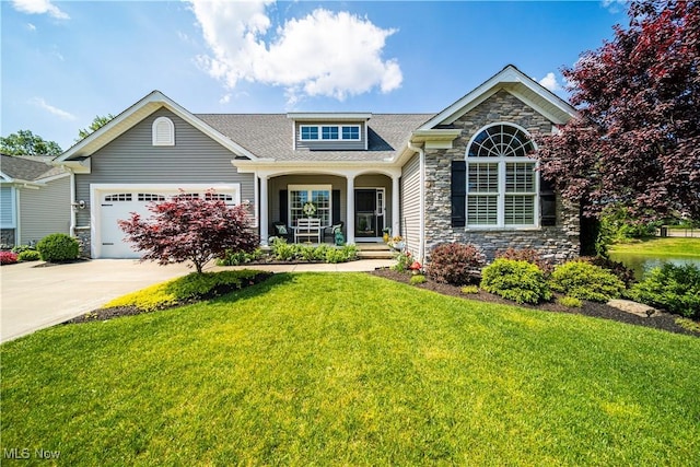 view of front facade with a garage, stone siding, driveway, and a front yard