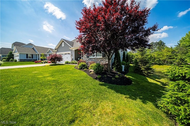 view of front of property featuring an attached garage, stone siding, a front yard, and driveway