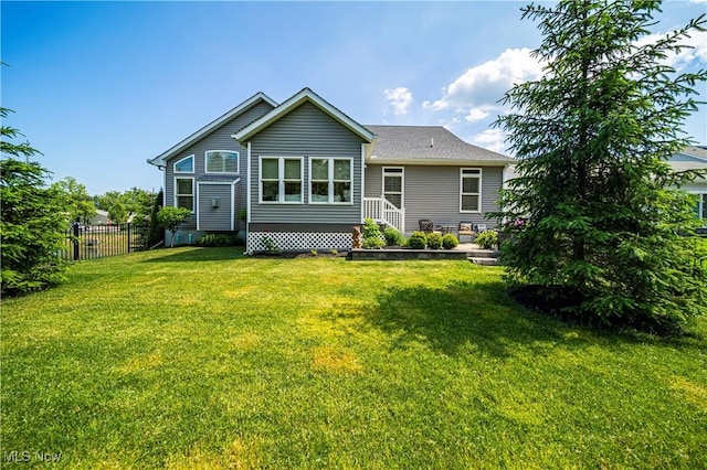 rear view of property with entry steps, a patio area, fence, and a yard