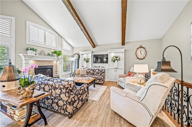 living area with vaulted ceiling with beams, light wood-type flooring, plenty of natural light, and a fireplace