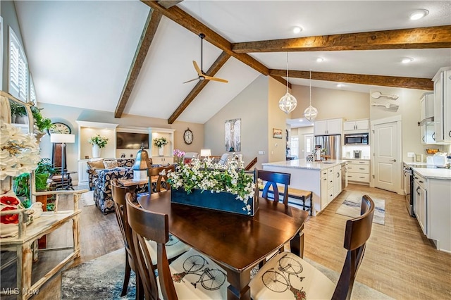 dining area featuring high vaulted ceiling, a wealth of natural light, beam ceiling, and light wood finished floors