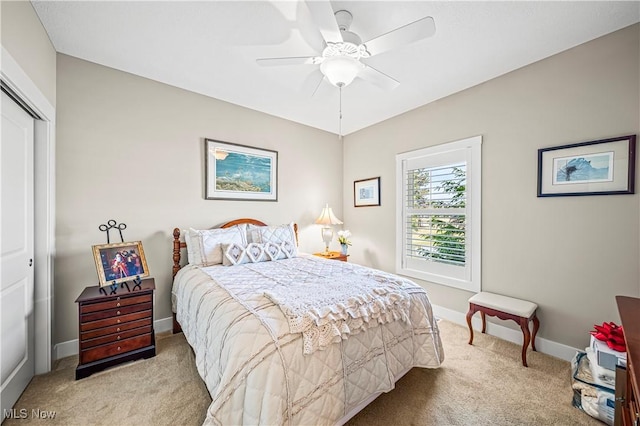 carpeted bedroom with ceiling fan, baseboards, and a closet