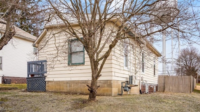 view of home's exterior with central AC unit and fence