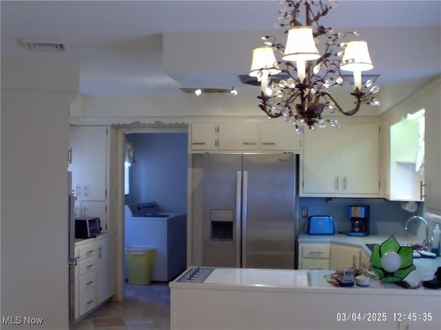 kitchen with light countertops, visible vents, appliances with stainless steel finishes, white cabinetry, and washer / dryer