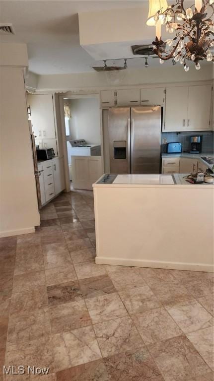 kitchen featuring tasteful backsplash, visible vents, pendant lighting, an inviting chandelier, and stainless steel refrigerator with ice dispenser