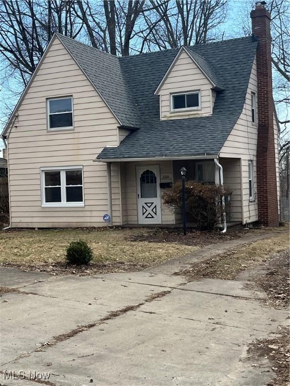 view of front of home featuring a shingled roof and a chimney