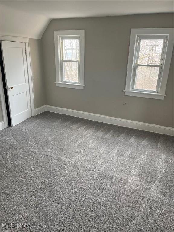 additional living space featuring carpet flooring, vaulted ceiling, and baseboards