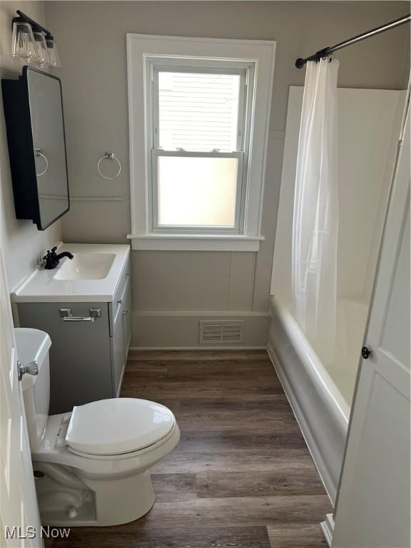 full bath with toilet, wood finished floors, vanity, visible vents, and baseboards