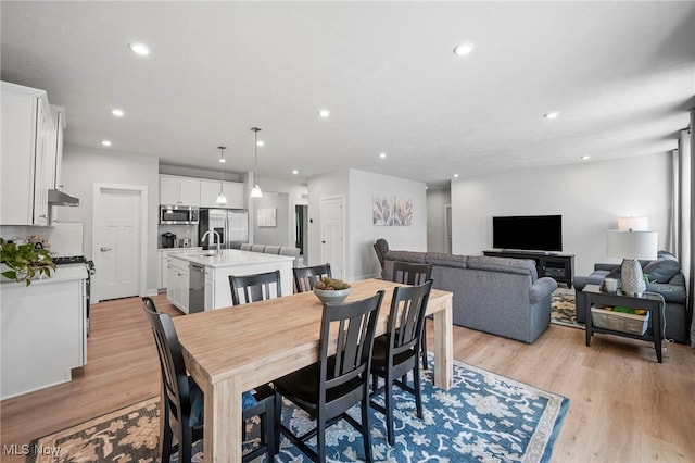 dining space with light wood-style floors and recessed lighting