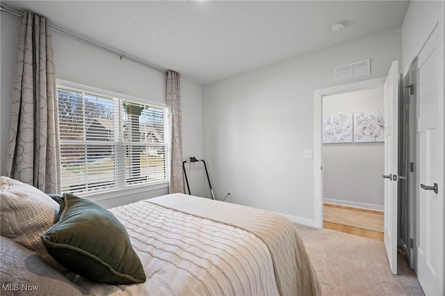 carpeted bedroom with visible vents and baseboards