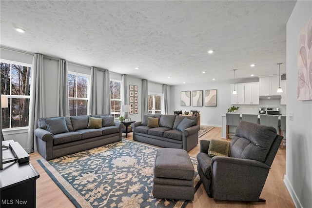 living room with a healthy amount of sunlight, light wood-style flooring, and recessed lighting