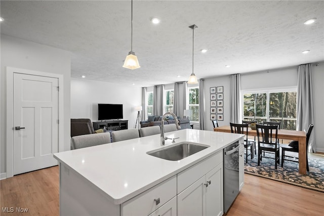 kitchen with dishwasher, plenty of natural light, a sink, and light wood-style floors