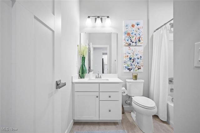 bathroom with shower / bath combination with curtain, vanity, toilet, and baseboards