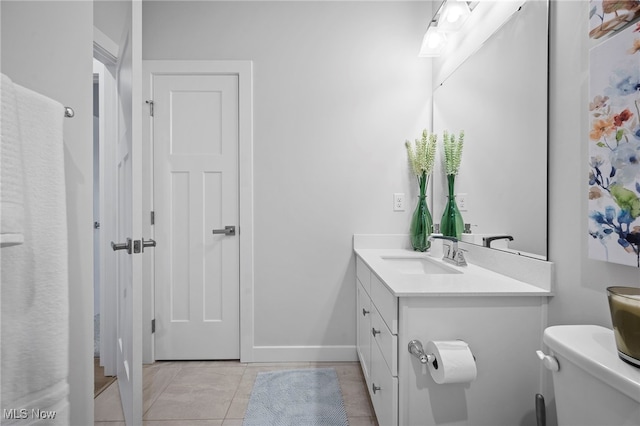 bathroom with toilet, tile patterned flooring, baseboards, and vanity