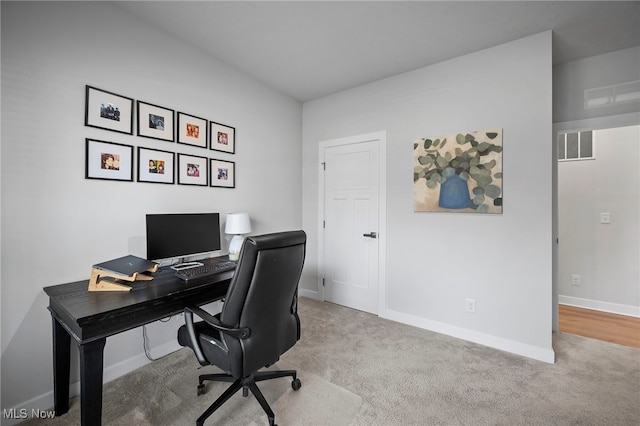 carpeted office with visible vents and baseboards