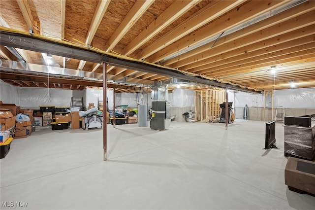 unfinished below grade area featuring heating unit and gas water heater