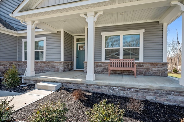 property entrance with stone siding and covered porch