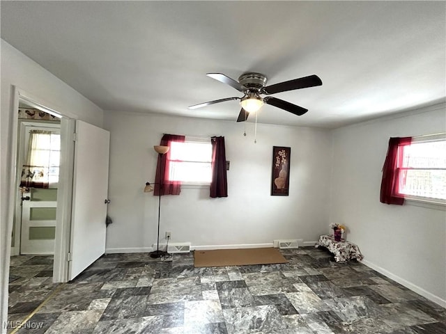 spare room featuring plenty of natural light, visible vents, and baseboards