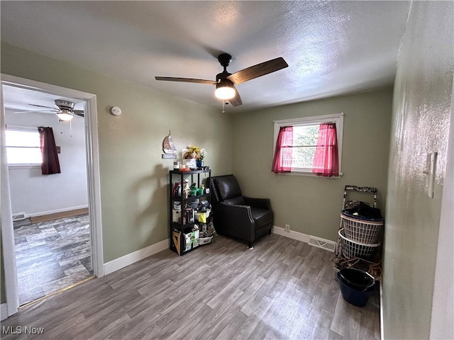 sitting room featuring visible vents, baseboards, and wood finished floors