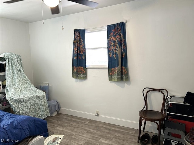 bedroom featuring ceiling fan, baseboards, and wood finished floors