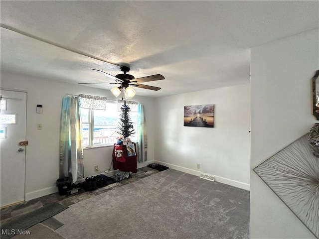 interior space with carpet, visible vents, baseboards, and ceiling fan