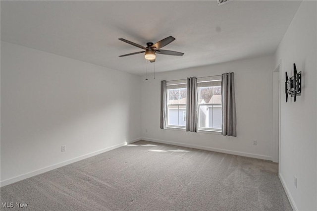 carpeted empty room featuring baseboards and a ceiling fan