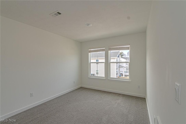 spare room featuring light carpet, baseboards, and visible vents