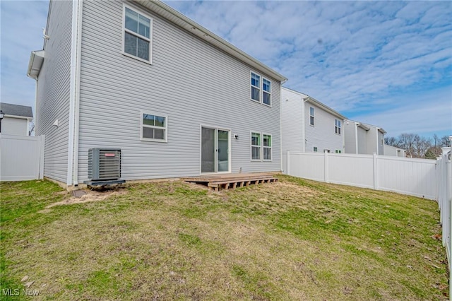 back of house featuring cooling unit, a fenced backyard, and a yard