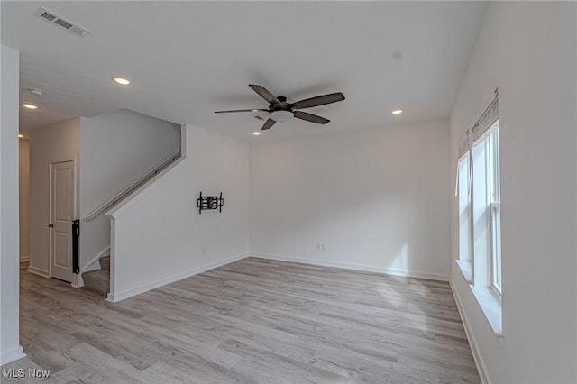 unfurnished room featuring light wood-type flooring, visible vents, recessed lighting, and stairs