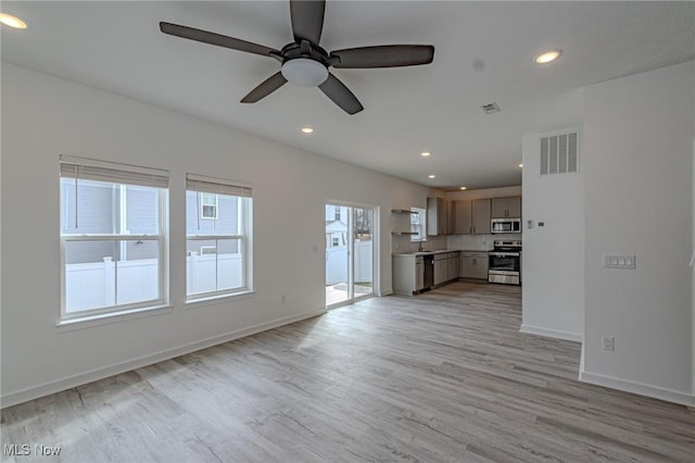 unfurnished living room with light wood-type flooring, visible vents, baseboards, and recessed lighting