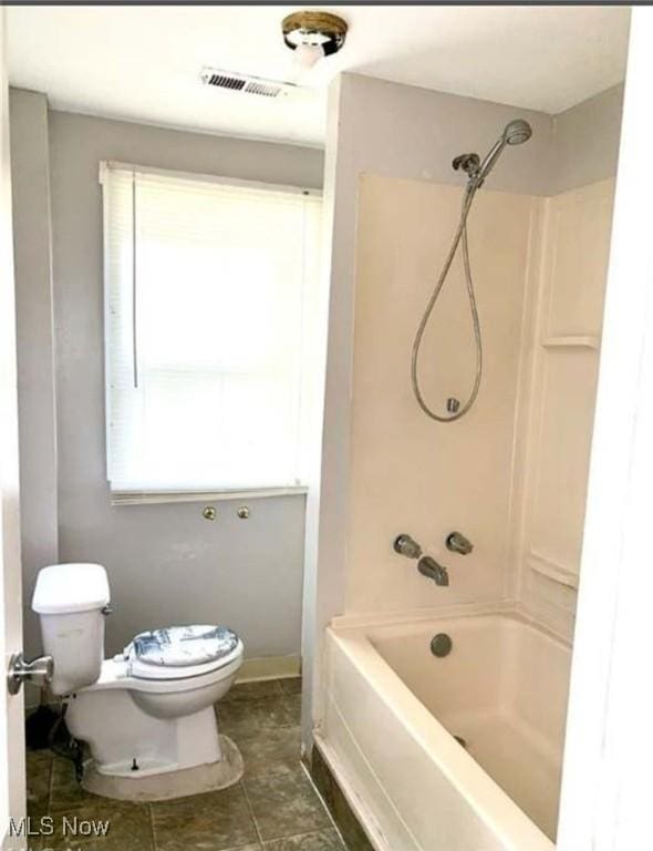 bathroom with toilet, shower / bathtub combination, and visible vents