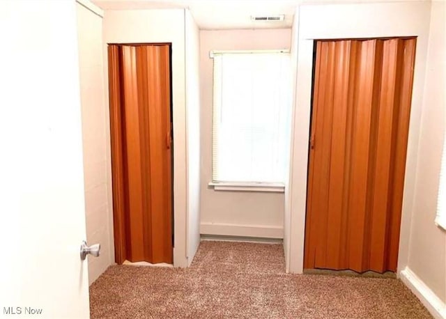 hallway with carpet flooring and visible vents