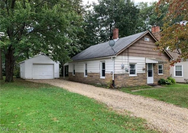 view of home's exterior with an outbuilding, a garage, dirt driveway, a lawn, and a chimney