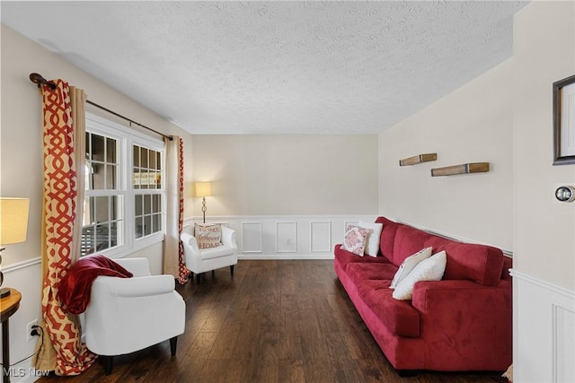 living area featuring a wainscoted wall, a textured ceiling, and wood finished floors