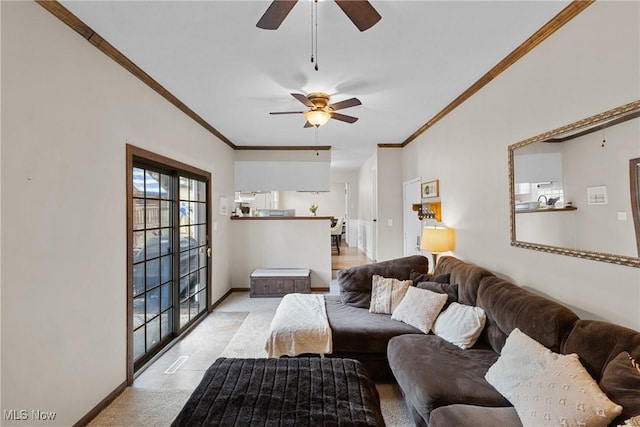 living room with a ceiling fan, baseboards, and crown molding