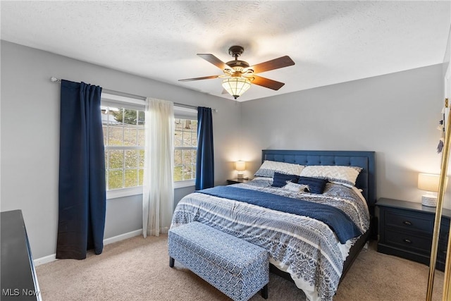 carpeted bedroom featuring a textured ceiling, ceiling fan, and baseboards