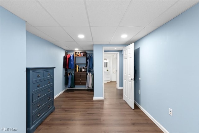 unfurnished bedroom with dark wood finished floors, a paneled ceiling, recessed lighting, a spacious closet, and baseboards