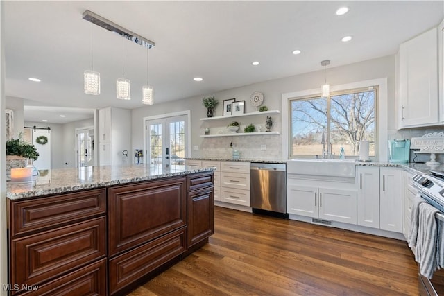 kitchen with stainless steel appliances, a sink, white cabinetry, french doors, and dark wood-style floors